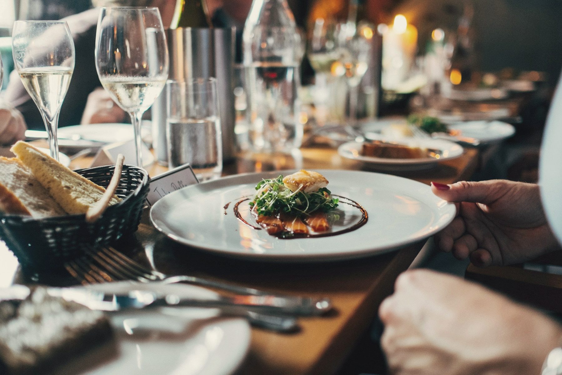 Plates being shared across a candlelit dinner table
