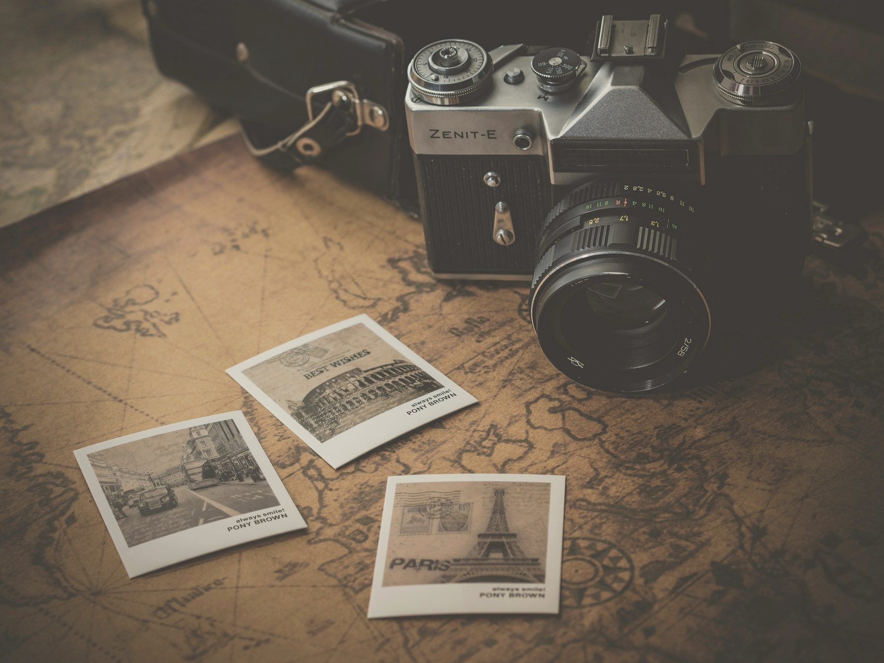 A vintage camera and instant prints on a wooden table