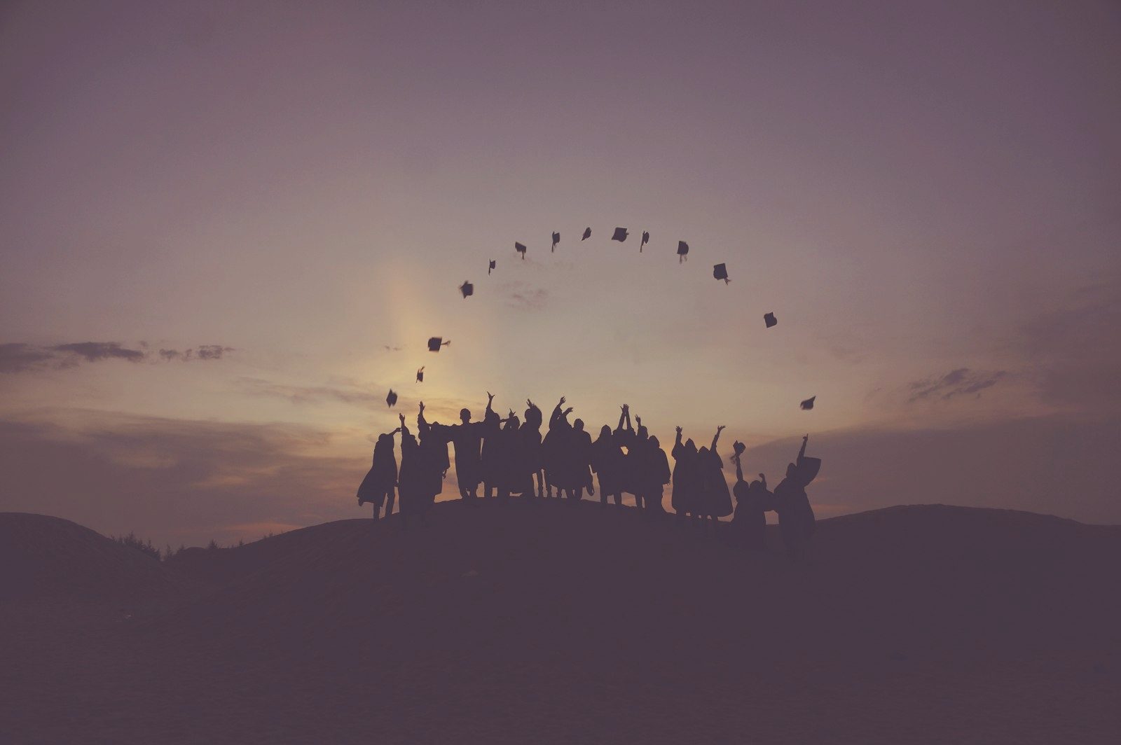 A crowd gathered on a hilltop at dusk