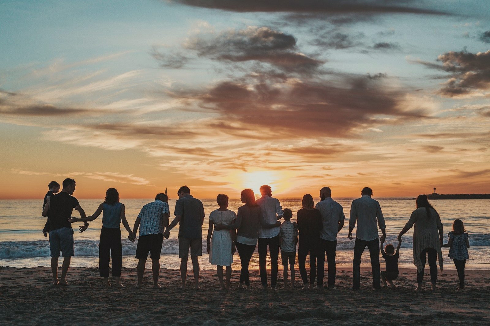 A group of people silhouetted against the sky at sunset