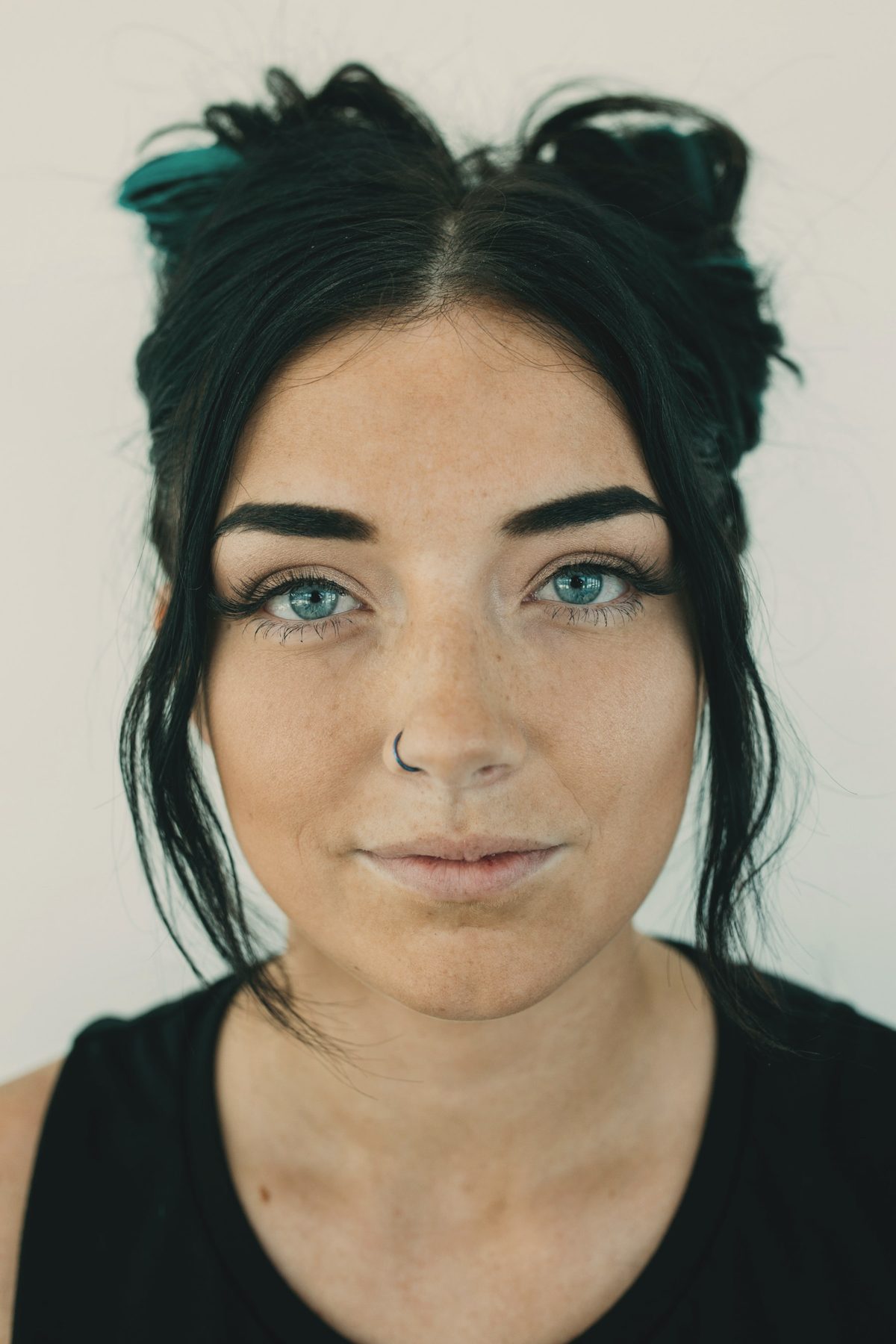 A woman with dark hair and freckles looking straight into the lens