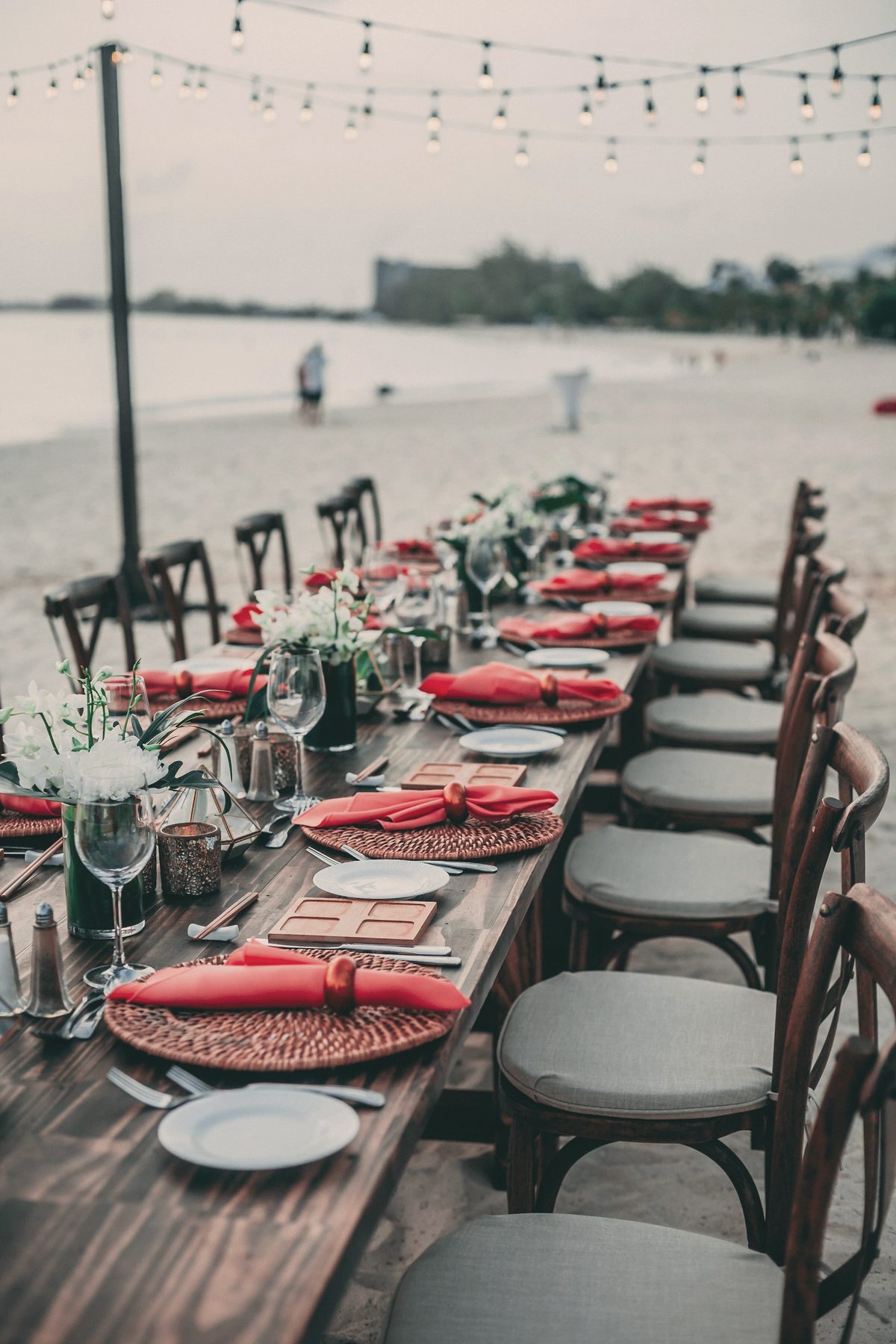 A long outdoor table set for a celebration at dusk