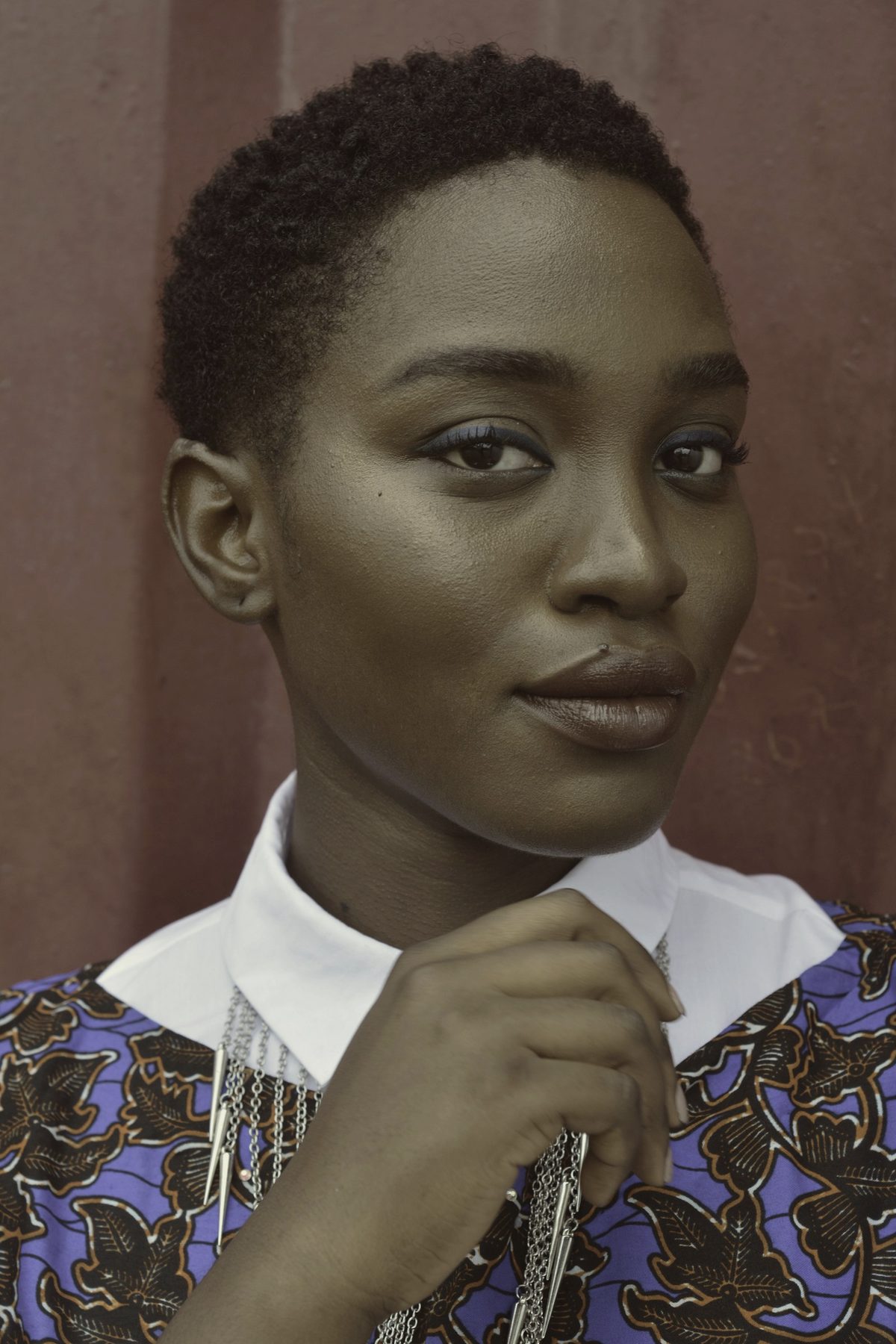 A woman with closely cropped hair in a patterned collar