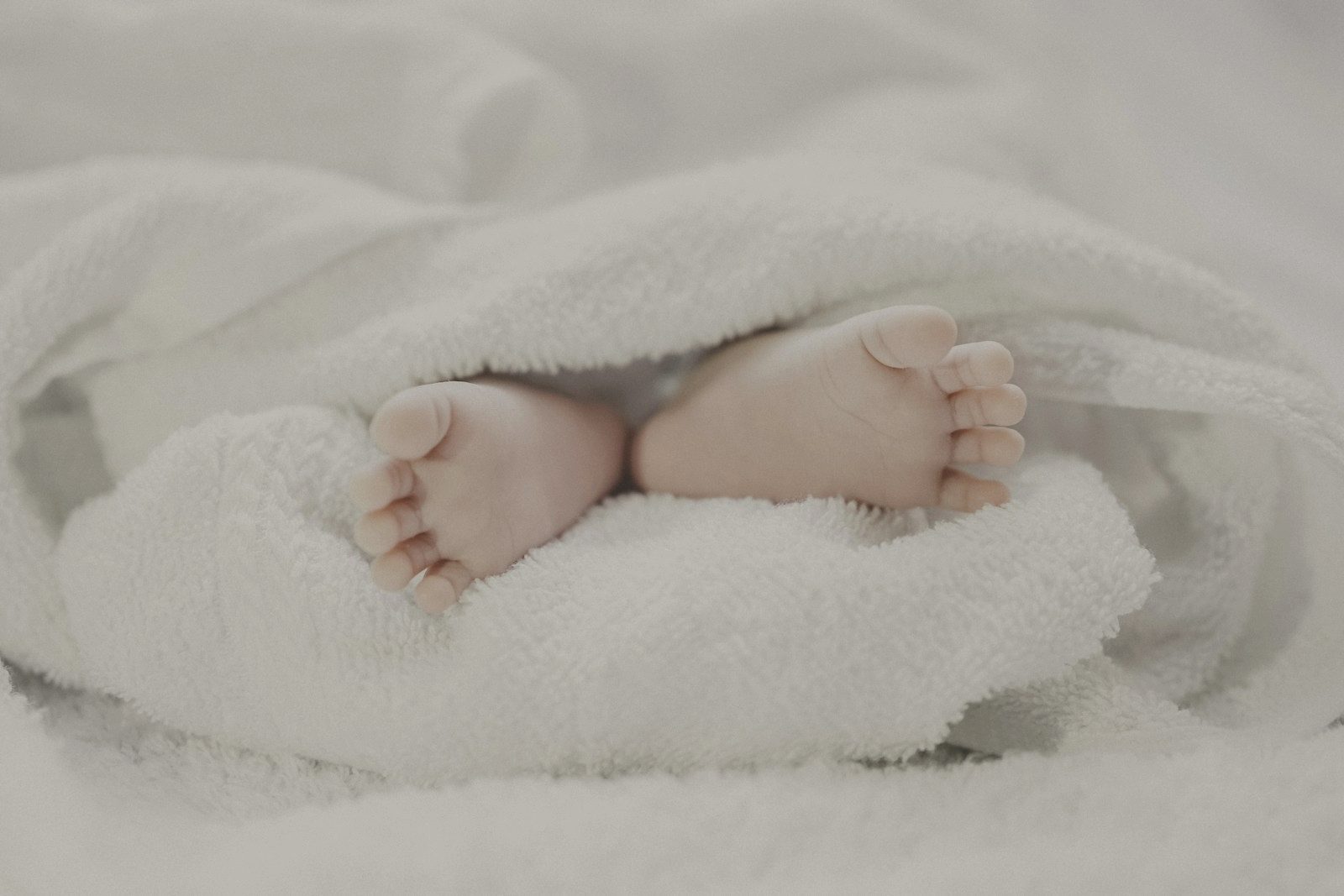 A newborn's feet against a soft blanket